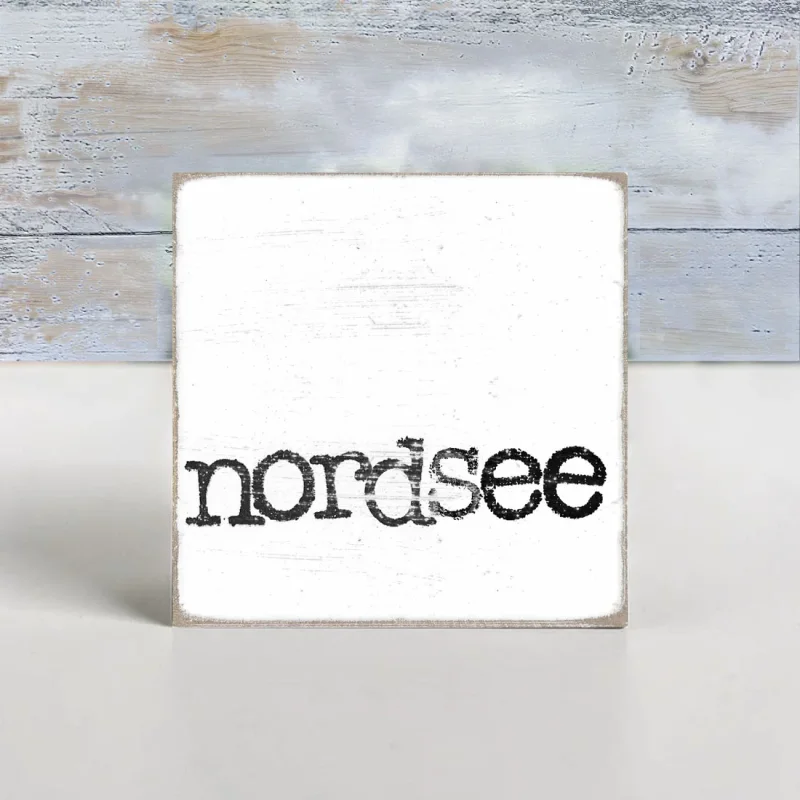 Maritimer Holzblock im Shabby Chic mit dem Schriftzug 'nordsee' in schwarzer Schreibmaschinenschrift auf weißem Hintergrund